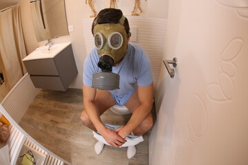 Man wearing gas mask in the toilet 