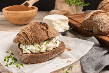 Rustic malt bread with cottage cheese, for breakfast or snack. Selective focus.