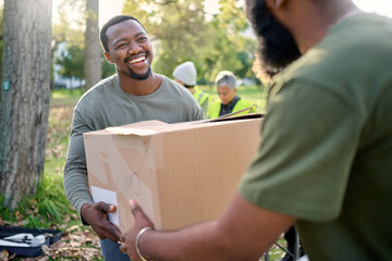 Black man, volunteering and giving box in park of donation, community service or social...