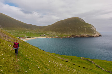 Woman hiking, St Kilda, Scotland, scenic view over Hirta bay and village.