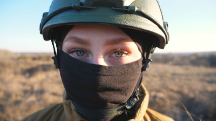 Sight of female ukrainian army soldier in helmet. Portrait of young woman in camouflage uniform...
