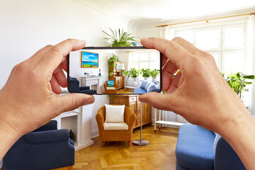 Augmented reality concept: hands holding smart phone with AR interior decoration app, visualising...