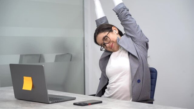 An enthusiastic young business lady stretching herself