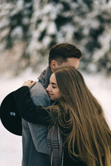 Happy young couple hugging and kissing outdoors. It's winter outside. Valentines day