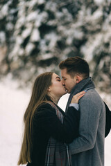 Happy young couple hugging and kissing outdoors. It's winter outside. Valentines day