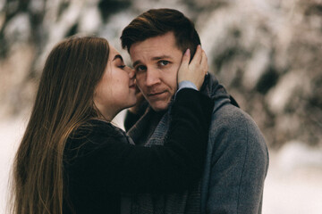 Happy young couple hugging and kissing outdoors. It's winter outside. Valentines day