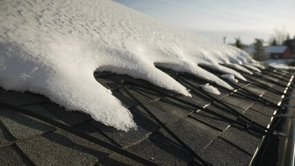 Winter heat cables on the edge of a roof melting snow - Powered by Adobe
