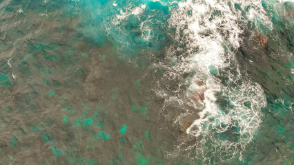 Turbulent waters near a rocky shoreline, amazing aerial view from drone
