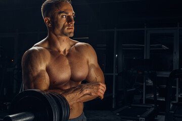Fototapeta na wymiar Shirtless muscular man before lifting weights in gym