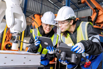 Women engineer team together at work in modern advanced robot welding machine sell service factory