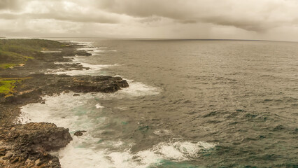 Turbulent waters near a rocky shoreline, amazing aerial view from drone