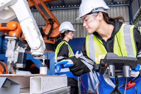 Women engineer team together at work in modern advanced robot welding machine sell service factory