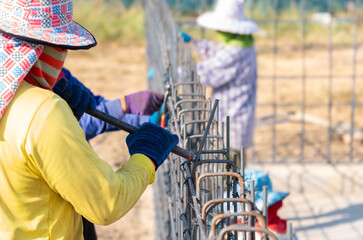 Worker keeps bending the metal rod in his hand.