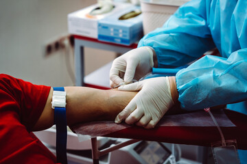 The hand of a man who donates blood. Male donor gives blood in a blood donation center. Nurse...