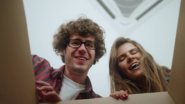 Smiling young couple opening a carton box and looking inside,gift,valentine,love,surprise gift and unpacking concept