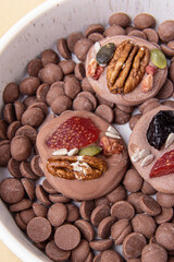 French sweets on chocolate callets. Chocolate candies with berries and nuts. Handmade mediants. Vertical