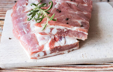 Raw pork ribs with rosemary and black pepper. on a wooden background