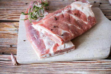 Raw pork ribs with rosemary and black pepper. on a wooden background
