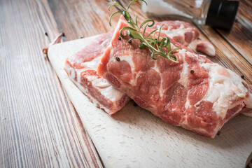 Raw pork ribs with rosemary and black pepper. on a wooden background