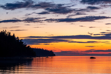 Fototapeta na wymiar sunset over the lake, calm and bright sky karelia