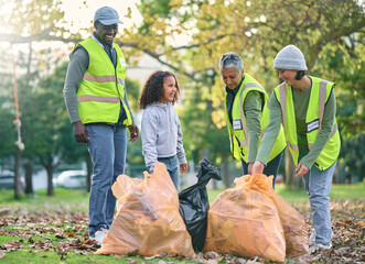 Child with volunteer group for cleaning park with garbage bag for a clean environment. Men, women...