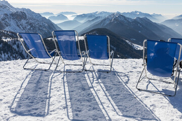 Sunbeds with a view of the Pinzolo valley. Inversion and fog over the ski area of Pinzolo (TN) Italy. A view from above of a fog-covered valley. Superski Dolomites, Italy.