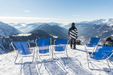 Sunbeds with a view of the Pinzolo valley. Inversion and fog over the ski area of Pinzolo (TN) Italy. A view from above of a fog-covered valley. Superski Dolomites, Italy. - obrazy, fototapety, plakaty