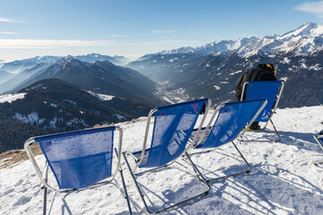 Sunbeds with a view of the Pinzolo valley. Inversion and fog over the ski area of Pinzolo (TN) Italy. A view from above of a fog-covered valley. Superski Dolomites, Italy.