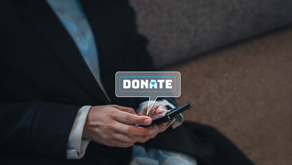 Close-up donate icon in bubble speech symbol appear on smart mobile phone in businessperson's hands in suit, sit on couch with copy space. Donation online by cellphone concept.