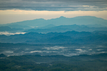 Obraz premium Layer of mountains at Central Java during sunrise and foggy condition 