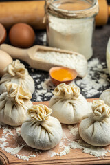 Raw Khinkali with meat on a wooden board. semi-finished products dumplings cooking khinkali. Georgian dumplings. Food recipe background. Close up