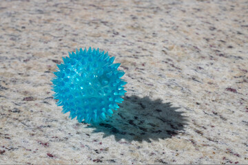 blue therapy massage ball, on the edge of a swimming pool, on a sunny day with concept of relaxation, vacations, spring brake