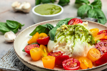 Salad with Tomatoes and Burrata cheese and green pesto on light background. banner, menu, recipe place for text, top view