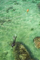 Pescador submarino en aguas color turquesa