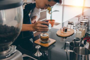 Male barista making coffee, frothed milk, decorated with great coffee pattern service beyond expectation Serve customers in world famous coffee shops