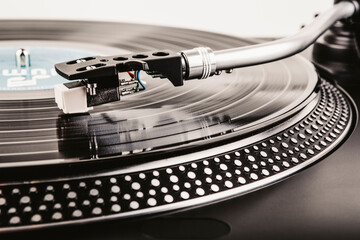 Playing a vinyl record on a turntable - Powered by Adobe