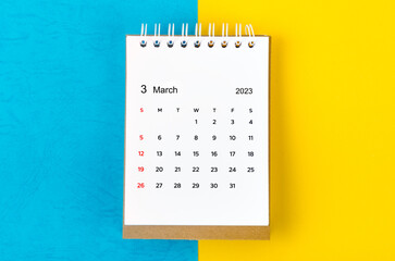 March 2023 Monthly desk calendar for 2023 year on blue and yellow background.