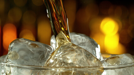 Super macro shot of pouring cola drink into glass.