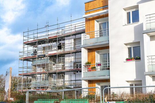 R&eacute;habilitation thermique de logements collectifs. R&eacute;fection de facades avec pose d'un  isolant et de bardage. Situation avant/apr&egrave;s