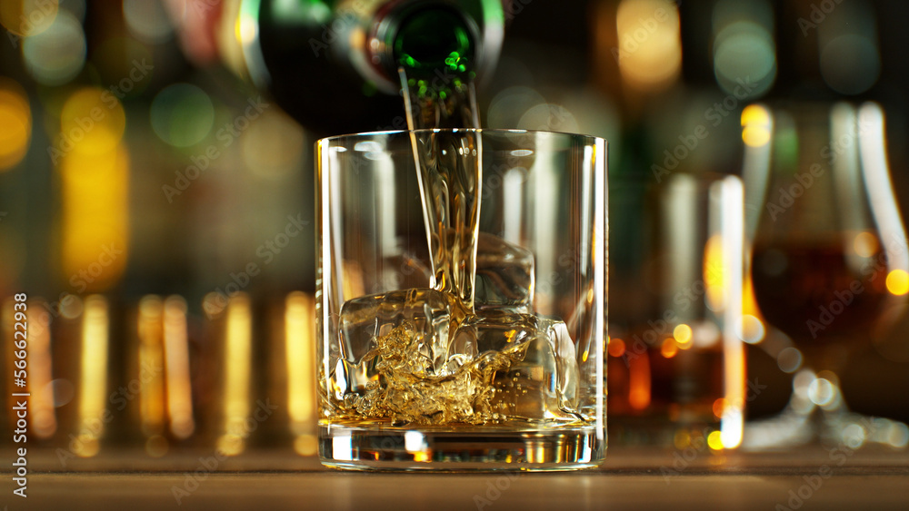 Wall mural Detail of pouring whiskey into glass with ice.