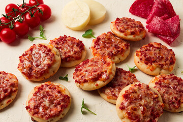Mini pizzas, salami with mozzarella cheese, on a white table, top view, no people,
