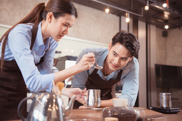 Before competing in the championship level coffee brewing competition, both of the baristas practice their coffee latte makeup techniques to become proficient.