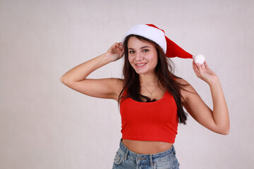 beautiful woman in red t-shirt and blue denim shorts and santa hat