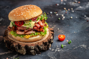 Craft beef burger with cheddar, lettuce and sauce on a wooden board, Hamburger. Fast food concept