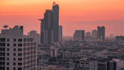 Fototapeta premium The high angle background of the city view with the secret light of the evening, blurring of night lights, showing the distribution of condominiums, dense homes in the capital community