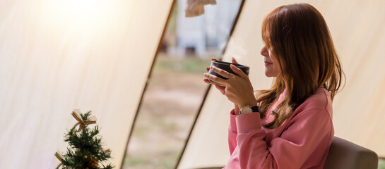 Portrait of Beautiful young Asian woman drinking fresh tea in a vintage ceramic cup bowl sitting by the balcony. Morning summer light feeling warm and relax. Healthcare or Herbal medicine concept.