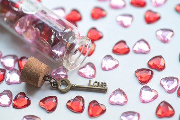 Key with the word love and heart shape gems on white background. Valentine's Day concept.
