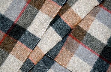 Background of woolen checkered fabric close up.