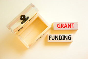 Grant funding symbol. Concept words Grant funding on wooden blocks. Beautiful white table white background. Wooden empthy chest. Business and grant funding concept. Copy space.
