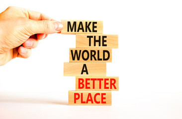 Make a better world symbol. Concept words Make the world a better place on wooden blocks. Beautiful white table white background. Businessman hand. Business make a better world concept. Copy space.